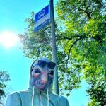 Carl the Alien stands outside an Edmonton Transit stop.