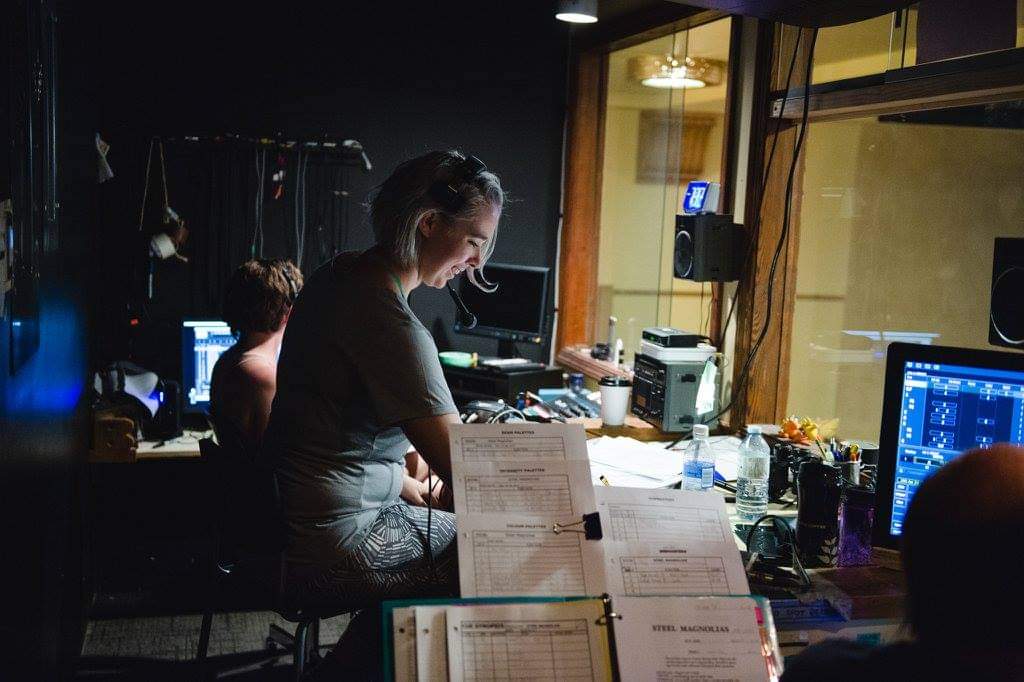 A Stage Manager prepares at a desk. 