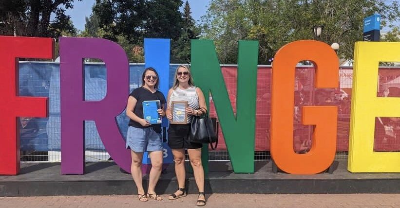 The ATB Gold ticket winner Jen stand with her friend by the giant Fringe sign.